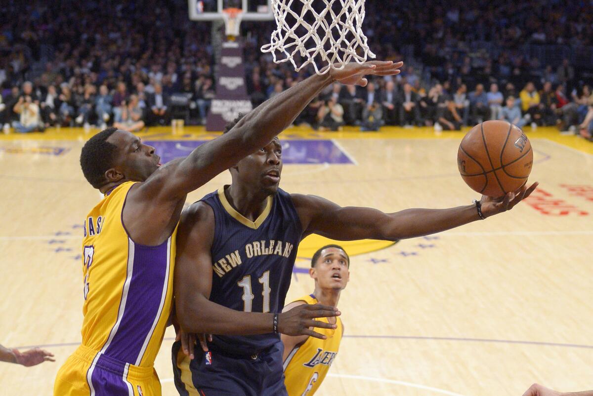 Pelicans guard Jrue Holiday drives to the basket against Lakers forward Brandon Bass during a game last season.