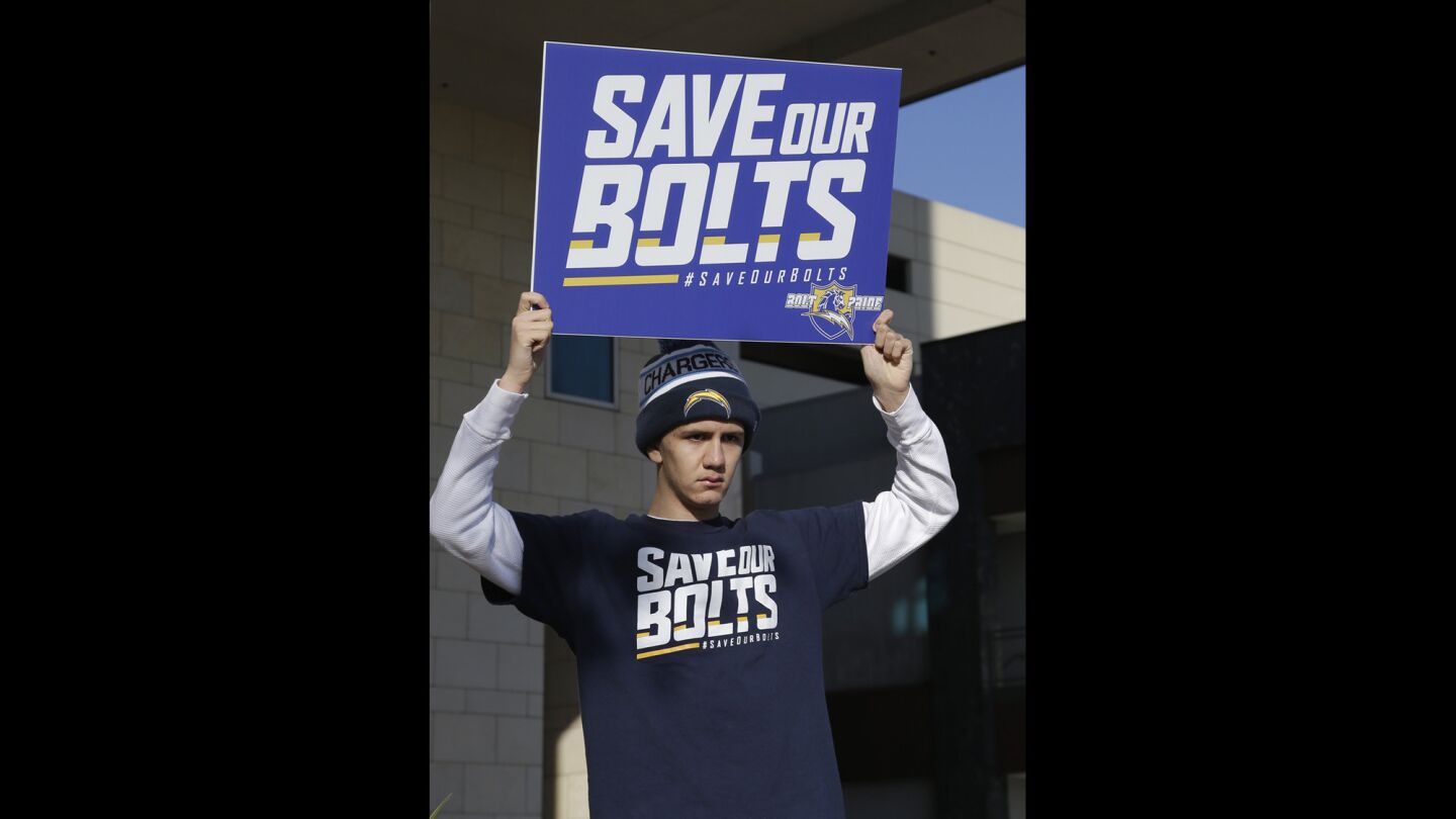 Chargers fan Richard Farley shows his feelings about keeping the team in San Diego, holding a sign outside the hotel where NFL owners are meeting in Houston on Jan. 12.