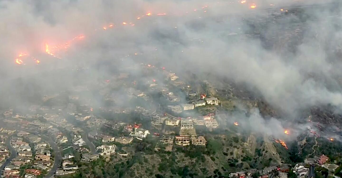 The brush fire broke out in the hills in Laguna Beach amid high temperatures and winds.