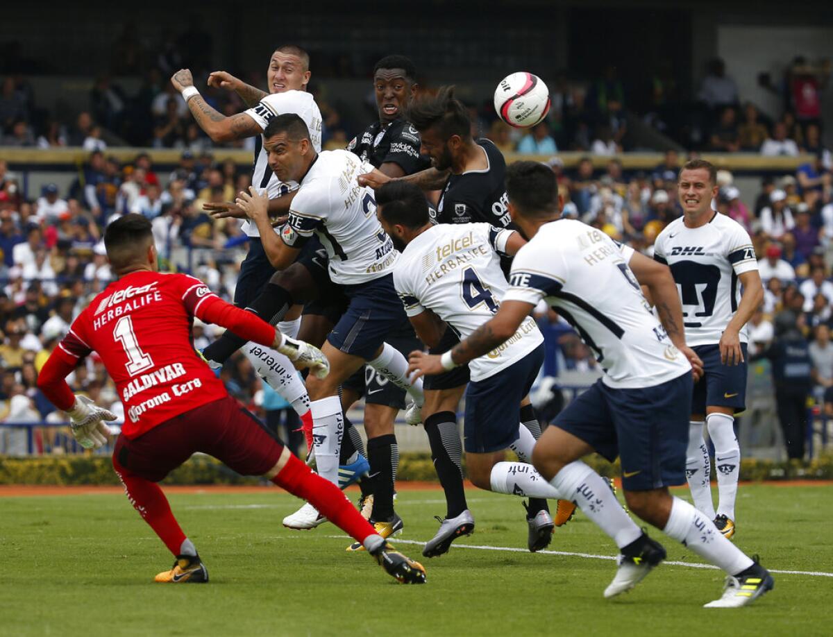 ARCHIVO - El delantero chileno de Pumas Nicolás Castillo (en el extremo izquierdo) se eleva para cabecear el balón ante Fabián Murillo (centro) y Robert Herrera (derecho) del Pachuca y frente a sus compañeros Gerardo Alcoba (3), el arquero Alfredo Saldívar (1), Luis Fernando Quintana (4) y Allan Mendoza (5) en un partido de la liga mexicana.