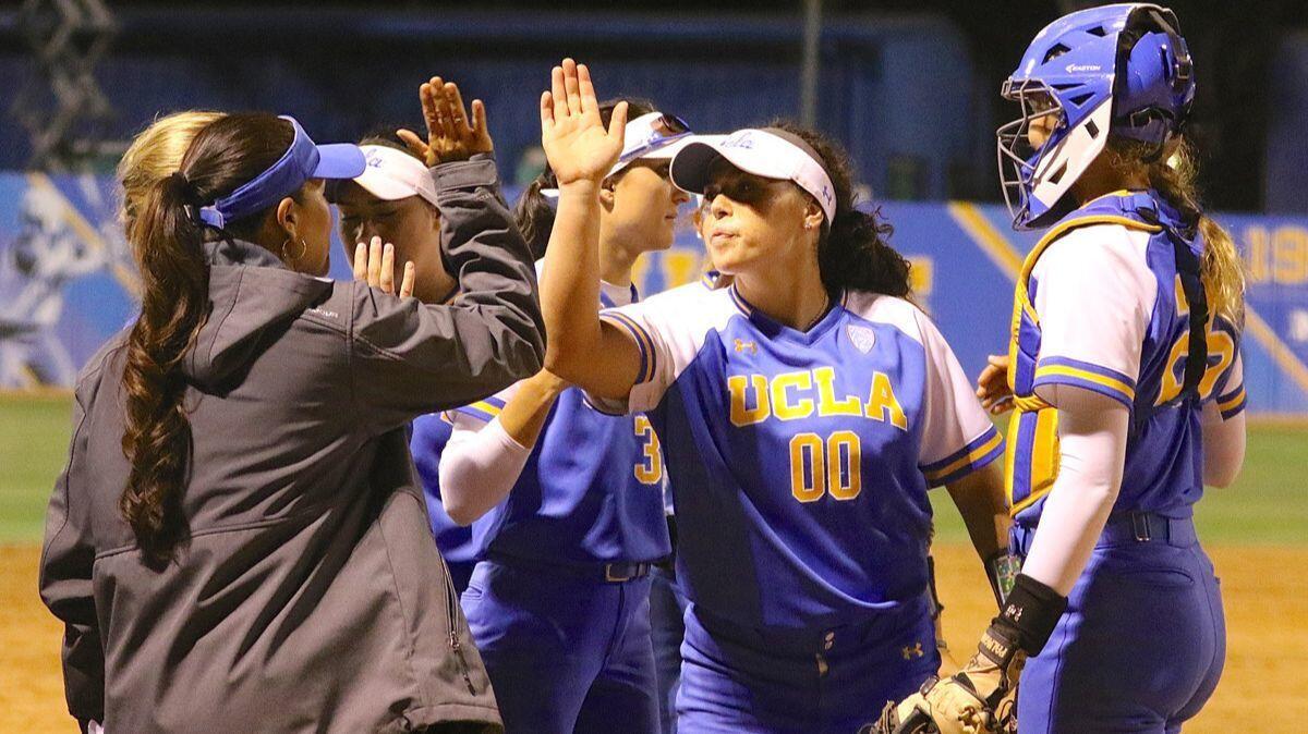 UCLA pitcher Rachel Garcia high-fives coach Kelly Inouye-Perez after the final out of the Los Angeles Regional final on May 20. The Bruins beat Cal State Fullerton 6-4.