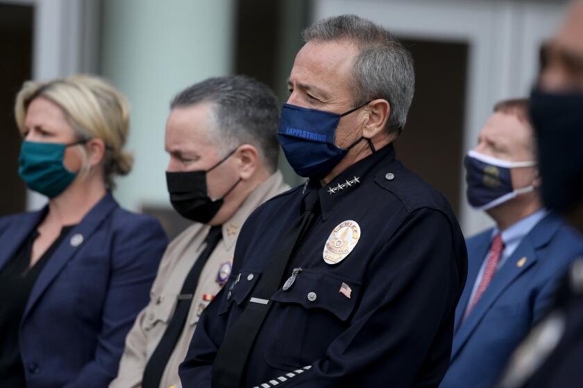 LOS ANGELES, CA - APRIL 12: Kristi Johnson, assistant director FBI Los Angeles, from left, L.A. County Sheriff Alex Villanueva and LAPD Chief Michel Moore, listen to faith leaders speak to the media at a press conference at Los Angeles Police Department (LAPD) Headquarters on Monday, April 12, 2021 in Los Angeles, CA. Faith and community leaders will call for emotional temperance during possible protests associated with the Derek Chauvin trial. (Gary Coronado / Los Angeles Times)