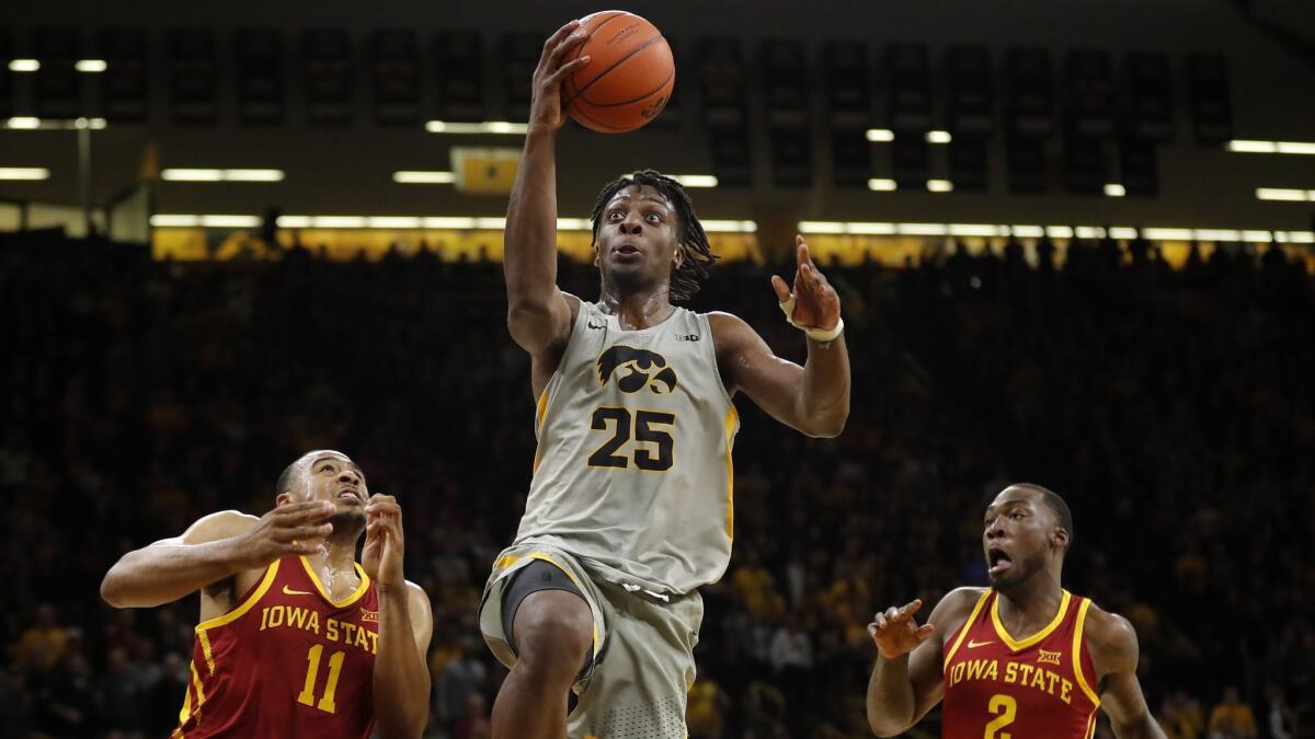 Iowa forward Tyler Cook (25) drives to the basket over Iowa State's Talen Horton-Tucker, left, and Cameron Lard, right, during the second half.