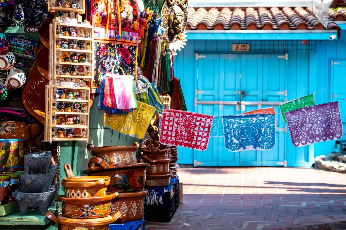 Papel picado and a stack of baskets and trinkets outside a stall on Olvera Street