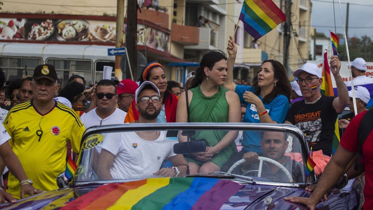 In a May 2018 photo, Mariela Castro, daughter of Raul Castro and director of Cuba's National Center for Sex Education, waves a rainbow flag while sitting in a convertible during the annual gay pride parade in Havana.