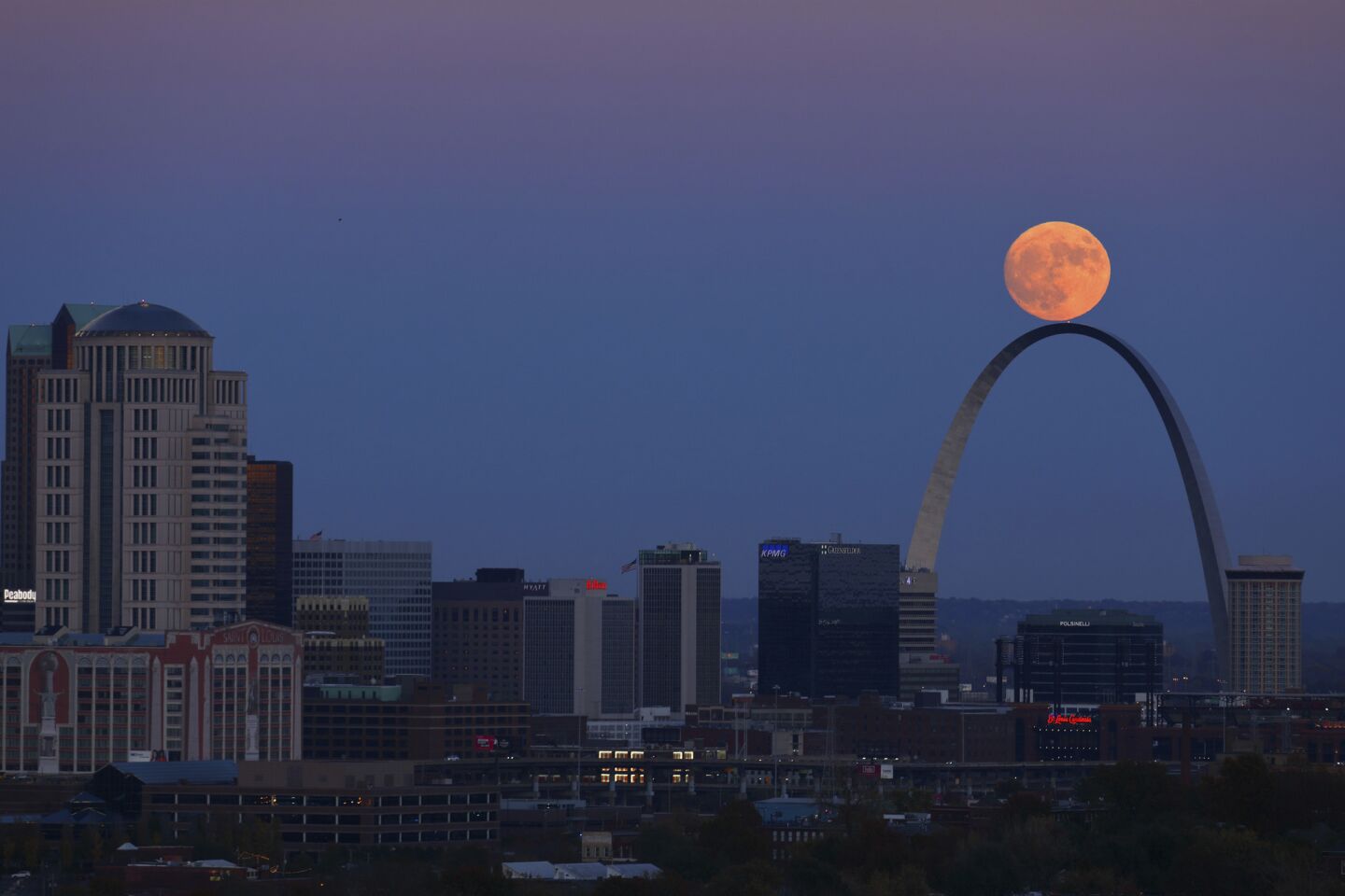 The moon rises beyond the Arch in St. Louis as seen from the Compton Hill Water Tower.
