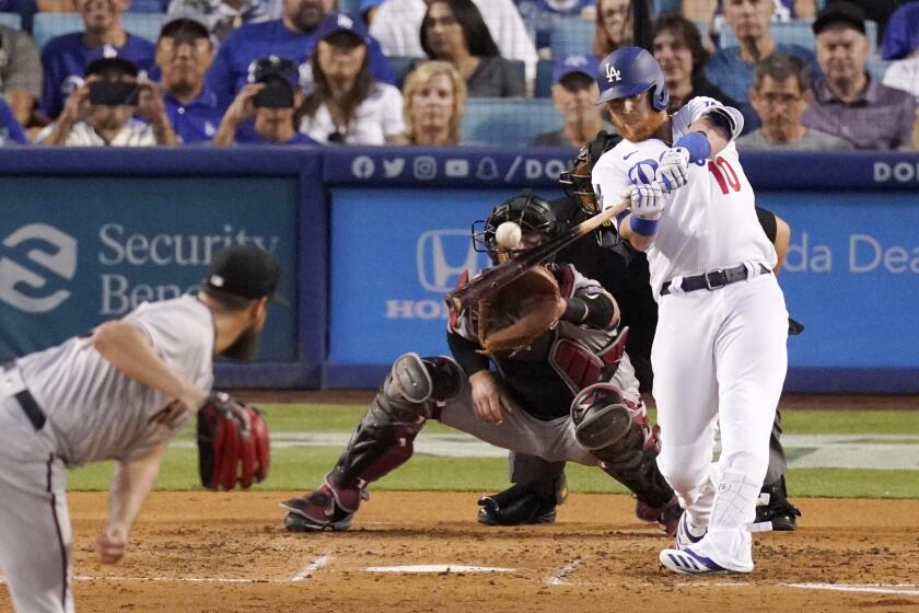 The Dodgers' Justin Turner hits a second-inning grand slam off Arizona Diamondbacks starter Caleb Smith on July 10, 2021.