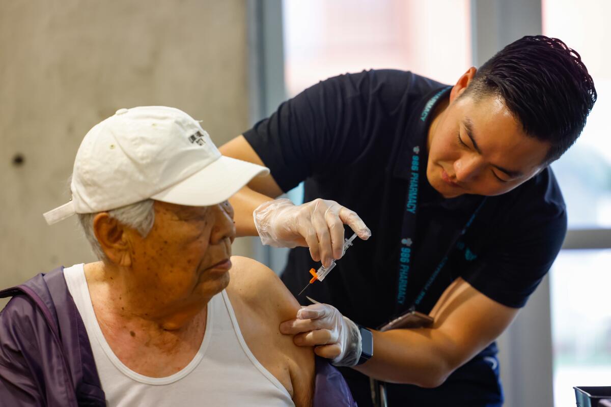 Dr. Yang Alex Ou administers a COVID-19 vaccination at Stovall Terrace Apartments on Oct. 11 in Los Angeles.