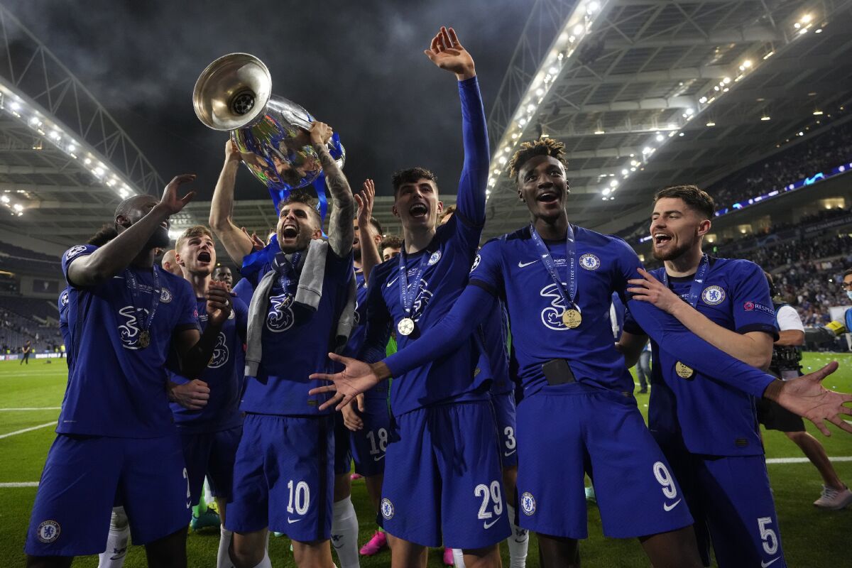 Chelsea's Christian Pulisic celebrates with teammates while holding up the Champions League trophy