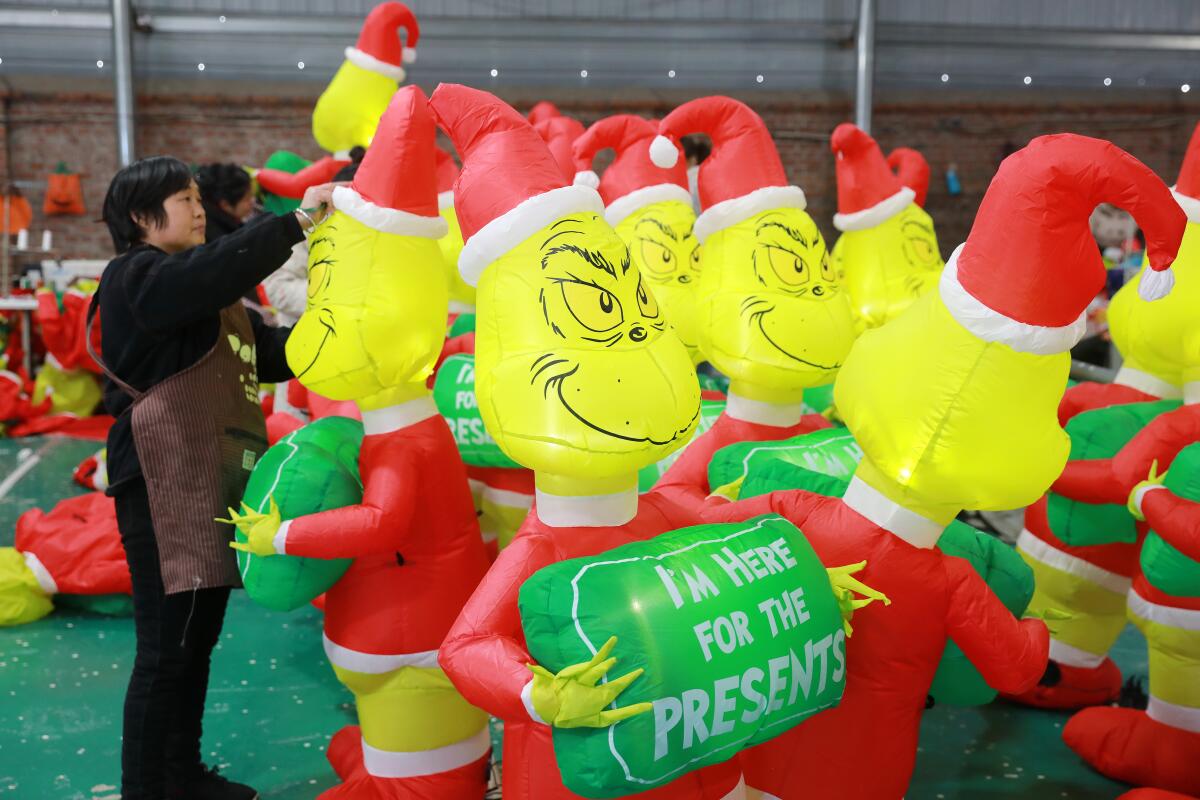 Workers check the inflated toys of The Grinch
