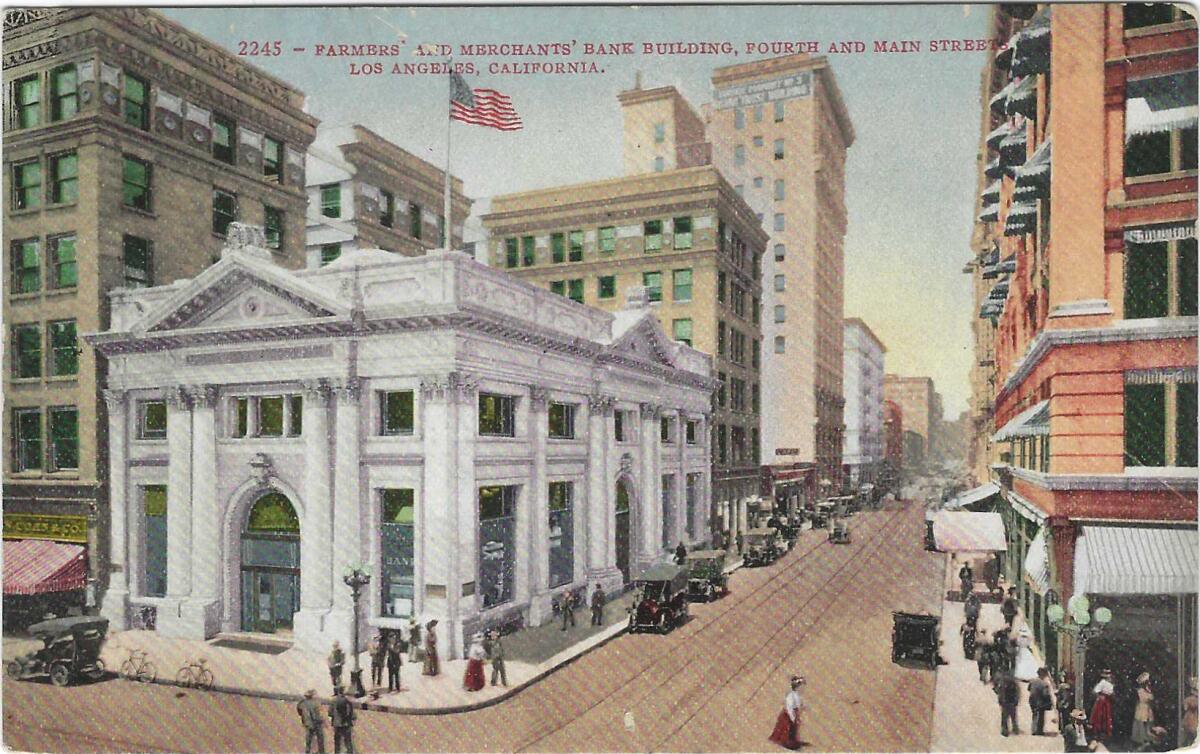 An American flag flies over the Classical Revival-style Farmers and Merchants bank on a bustling street corner.