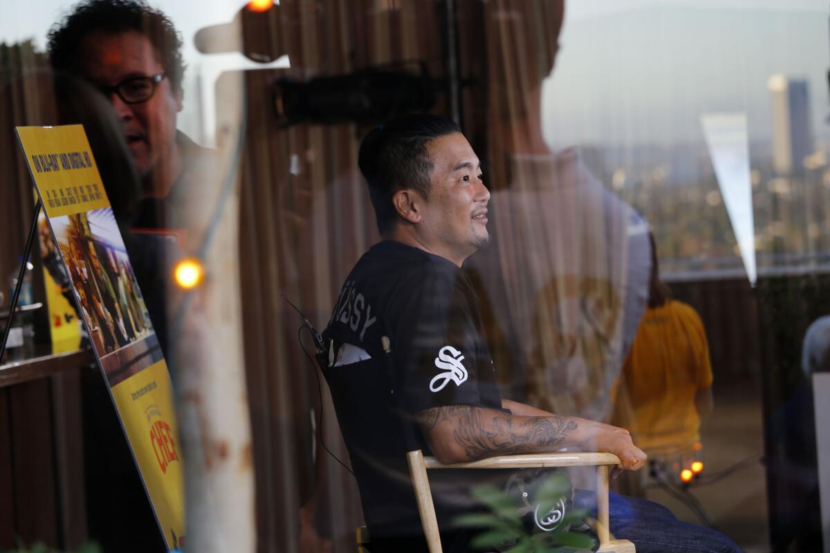 Jon Favreau, reflected in glass on the left, and chef Roy Choi took part in a DVD launch of the film "Chef" on Tuesday evening.