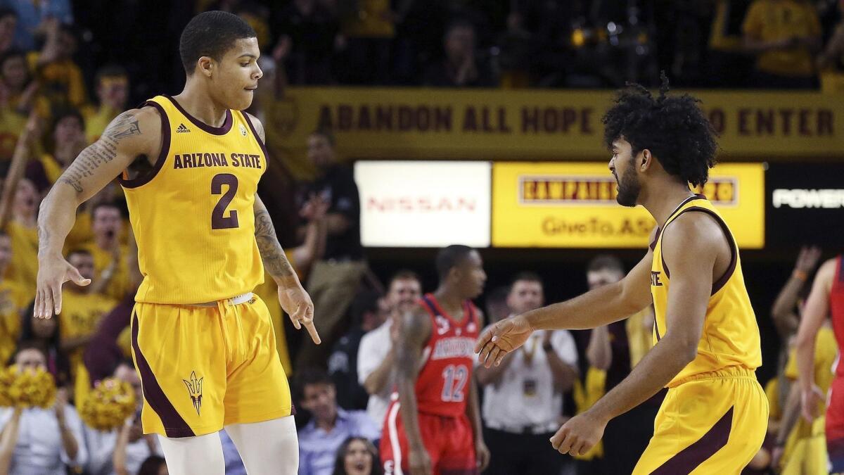 Arizona State guard Rob Edwards (2) celebrates a three-point basket against Arizona with teammate Remy Martin, right, during the first half.