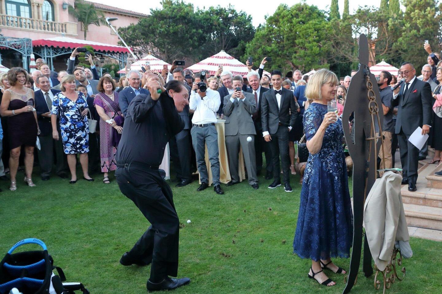 Phil Mickelson demonstrate the ?lob shot? with assistance from auction winner Sue Wagner