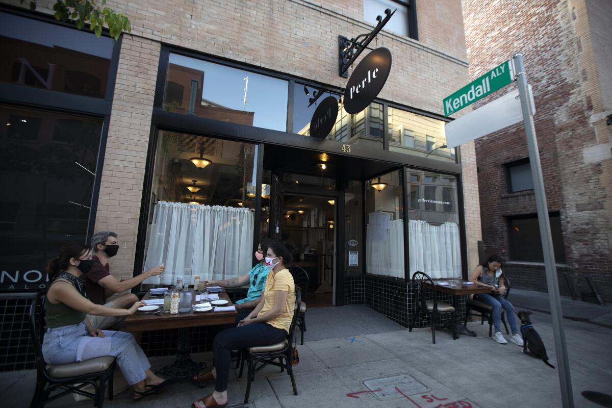 Patrons sit at tables outside Perle Restaurant in Pasadena.