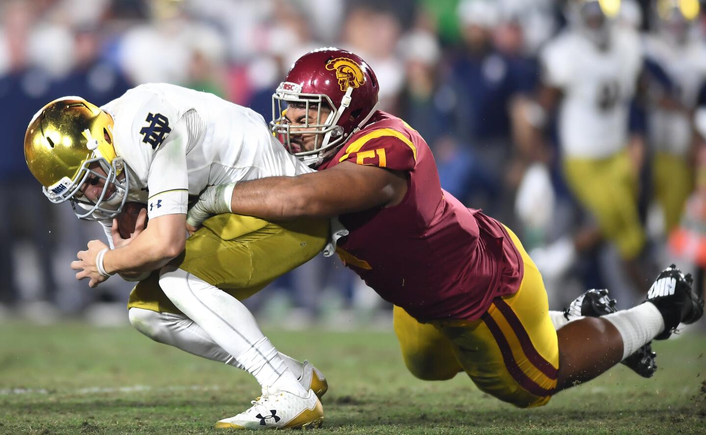 USC's Marlon Tuipulotu sacks Notre Dame quarterback Ian Book in the second quarter at the Coliseum.