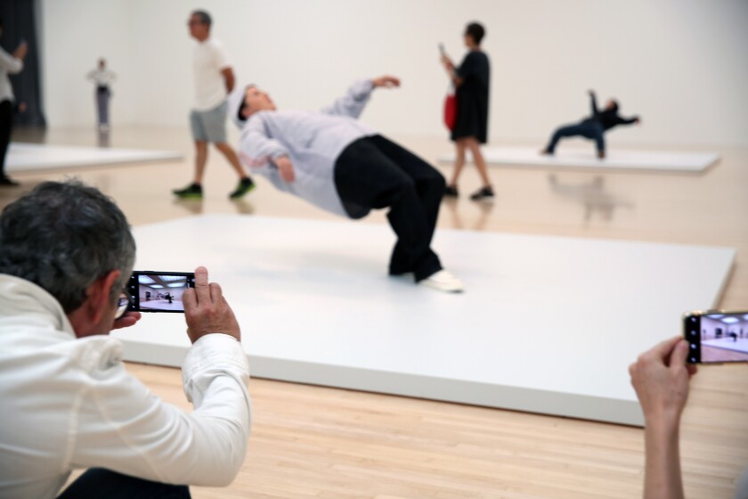 Visitors photograph the live sculptures in artist Xu Zhen's "In Just a Blink of an Eye." MOCA acquired the performance piece for its permanent collection. 