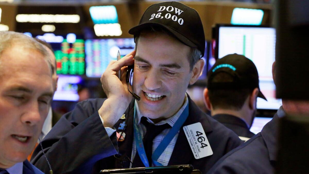 Trader Gregory Rowe wears a "Dow 26,000" hat on the floor of the New York Stock Exchange.