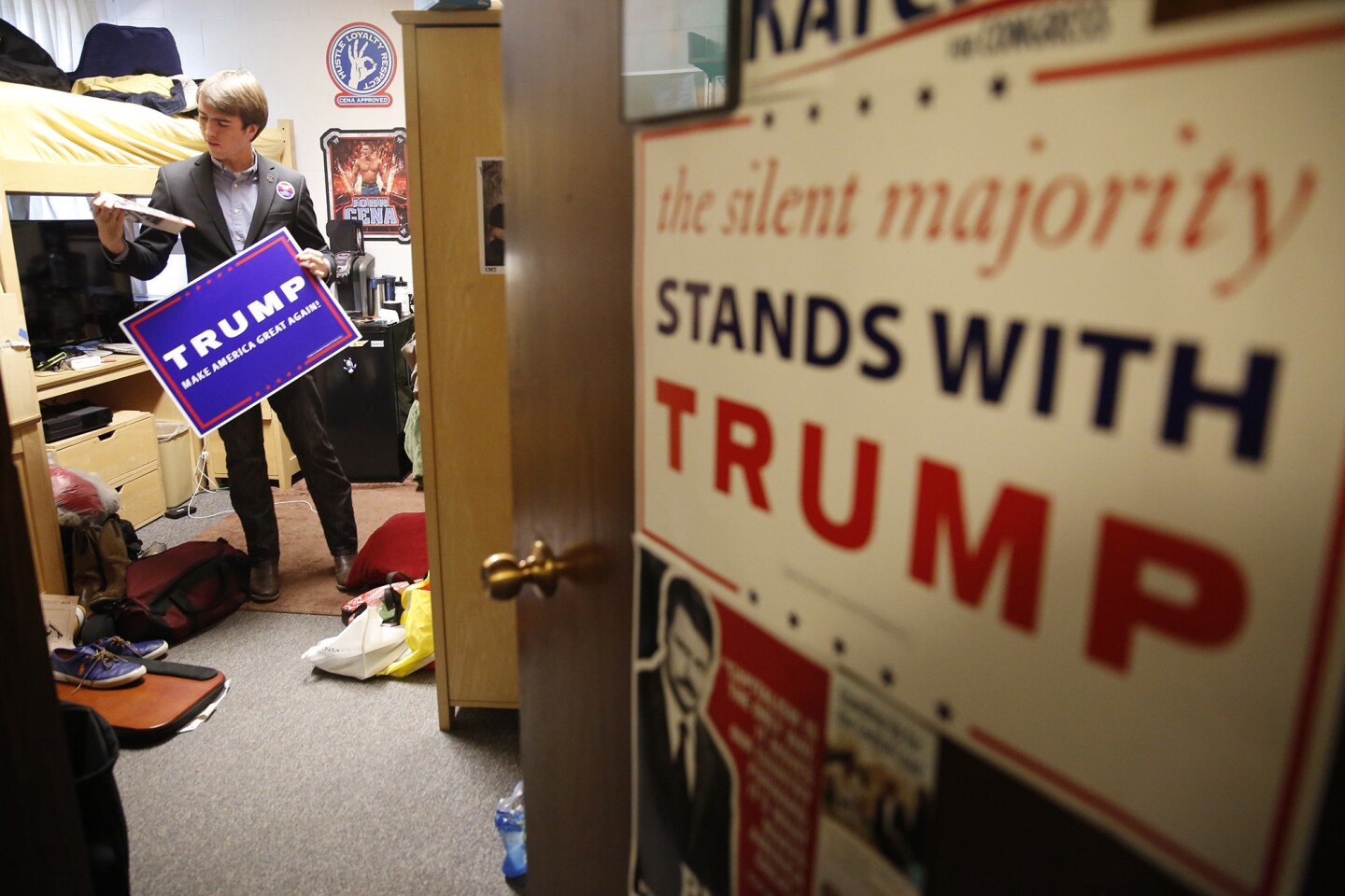 Donald Trump supporter and Westmont College student Jake Lopez grabs a Trump campaign poster in his dorm room to take out on campus in Montecito, Calif.