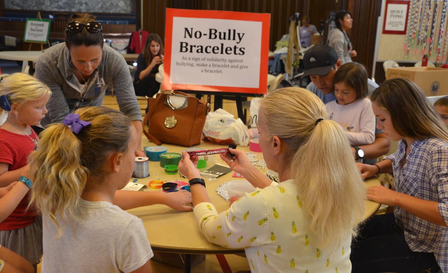 Volunteers create No-Bully bracelets to spread the word during the 2014 Hearts & Hands presented by the Newport-Mesa-Irvine Interfaith Council held Saturday.