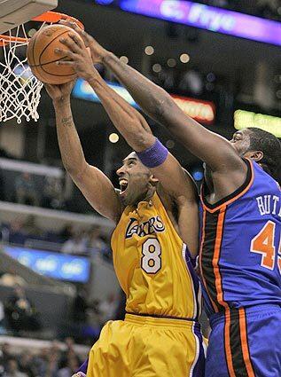 Lakers' Kobe Bryant pulls down a rebound in front of the New York Knicks' Jackie Butler.