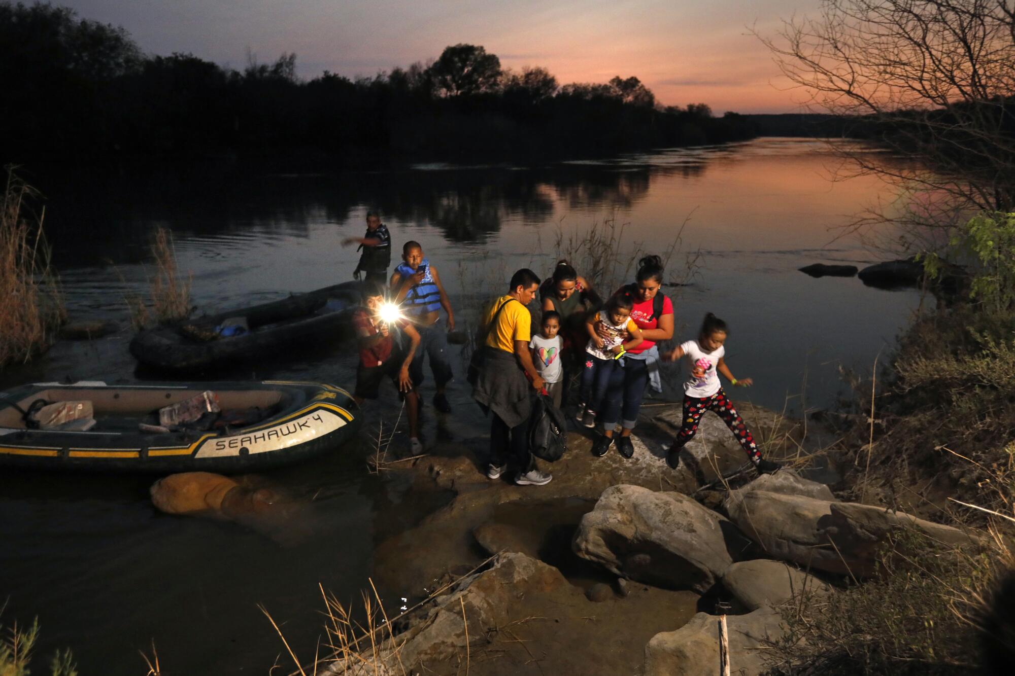 Migrants land on the U.S. side after crossing the Rio Grande in a small boat