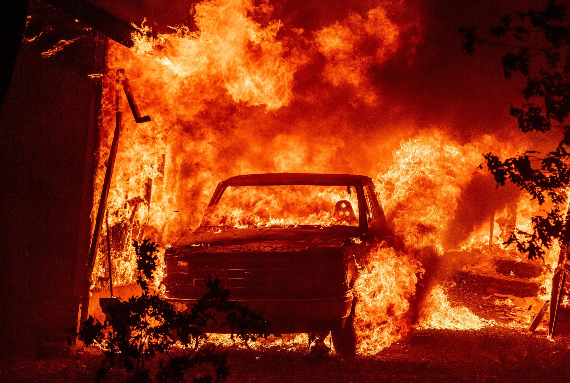 A truck and home burn as the Dixie fire tears through the Indian Falls neighborhood of unincorporated Plumas County, Calif.