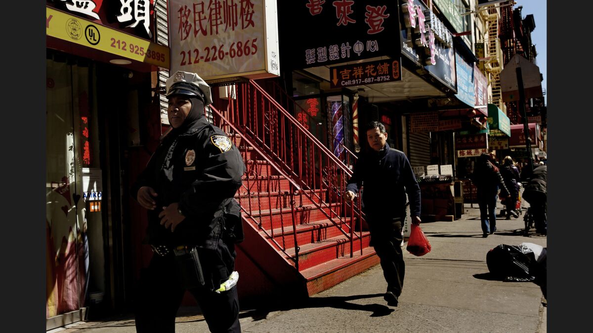 A police officer patrols on the edge of New York's Chinatown.