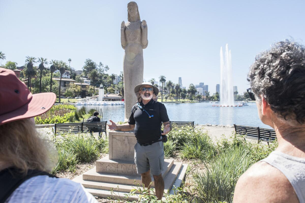 Stair tour leader Dan Gutierrez talks about the history of the Queen of the Angels statue at Echo Park Lake during a 15-mile guided walking tour.