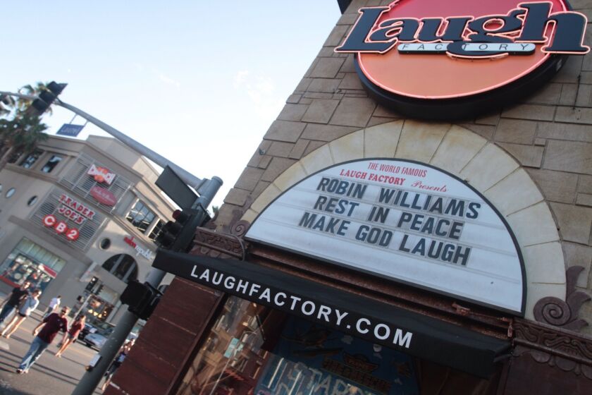 Tourists walk past Robin Williams' memorial at the Laugh Factory at Sunset Boulevard and Laurel in Hollywood on Aug. 11, 2014.