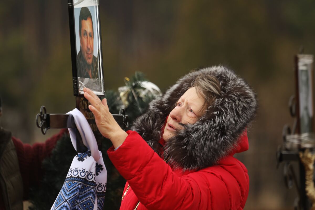 Lyudmila Goncharenko mourns her husband, Nickolay, at a cemetery in Irpin, Ukraine.