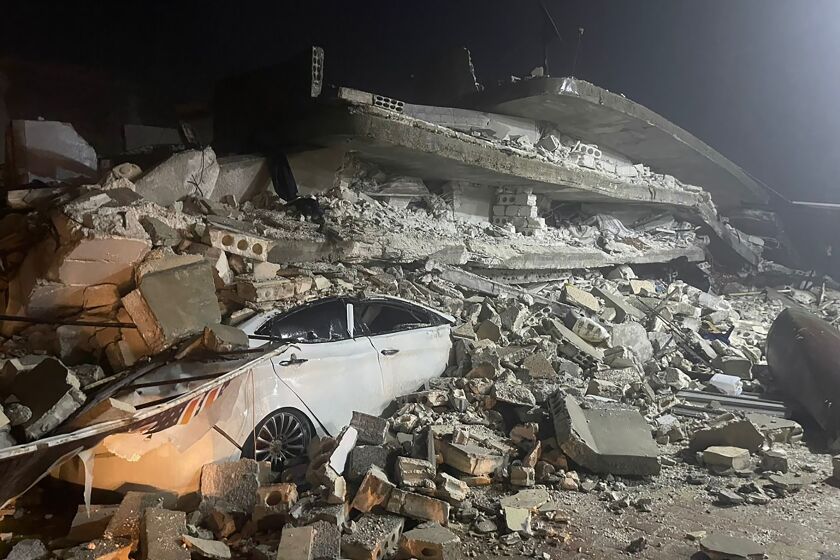 A car is seen under the wreckage of a collapsed building, in Azmarin town, in Idlib province, northern Syria, Monday, Feb. 6, 2023. A powerful earthquake has caused significant damage in southeast Turkey and Syria and many casualties are feared. Damage was reported across several Turkish provinces, and rescue teams were being sent from around the country. (AP Photo/Ghaith Alsayed)