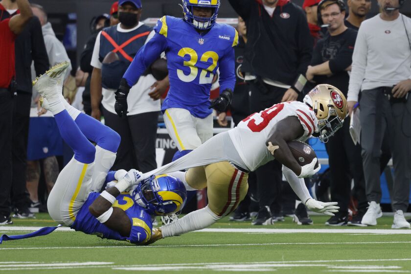 INGLEWOOD, CA - JANUARY 9, 2022: Los Angeles Rams safety Nick Scott (33) tackles San Francisco 49ers wide receiver Deebo Samuel (19) by his undershirt in the second half on January 9, 2022 at SoFi Stadium in Inglewood, California.(Gina Ferazzi / Los Angeles Times)