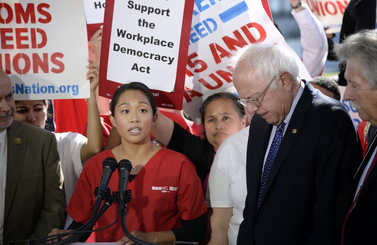 Allysha Almada, a nurse who tried to organize a union and was later fired, speaks alongside presidential hopeful Bernie Sanders last month in Washington.