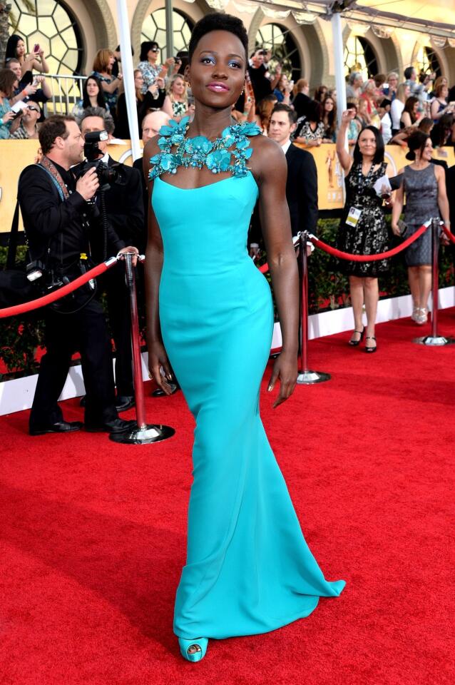 Nyong'o wears a turquoise Gucci gown to the 20th annual Screen Actors Guild Awards.