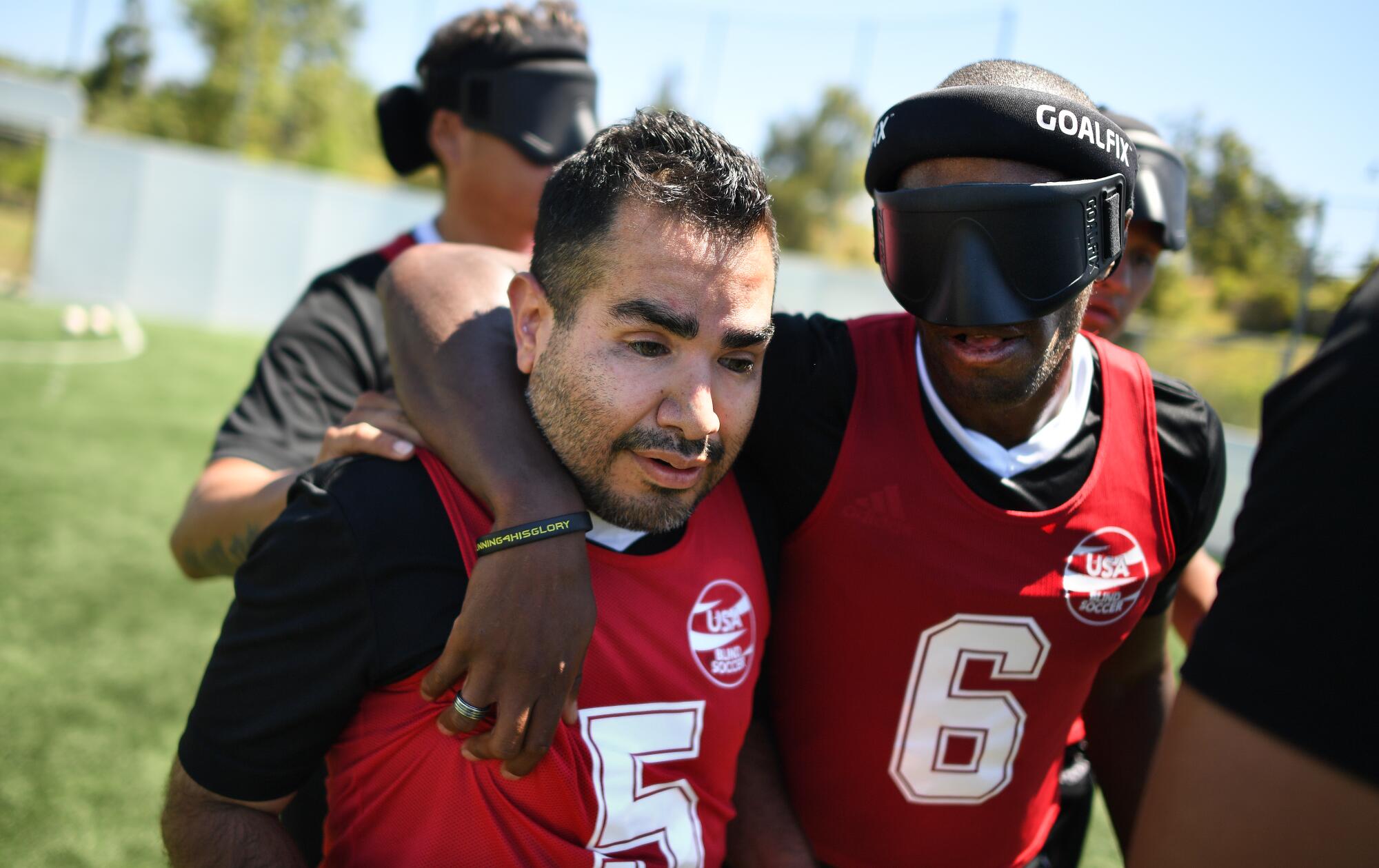 Blind soccer players Alvaro Mora Arellano and David Brown embrace following a scrimmage