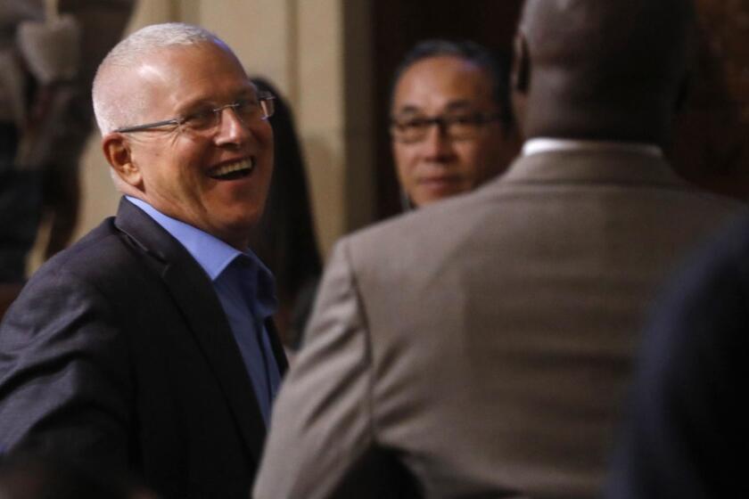 LOS ANGELES, CA - DECEMBER 11, 2018 - - Los Angeles City Councilman Mike Bonin, left, smiles after the Los Angeles City Council unanimously approved an ordinance regulating Airbnb and other homesharing platforms in Los Angeles at City Hall on December 11, 2018. The ordinance that was approved by the council allows qualified hosts to rent year-round, for which industry advocates had been lobbying. Hosts could petition for more than 120 days by meeting certain criteria, including that the property has not been the subject of too many nuisance violations. Tuesday's vote comes more than three and a half years after Councilman Bonin first laid out a proposal to regulate short-term rentals, arguing that the city needed to prevent homes from being operated like hotels. (Genaro Molina/Los Angeles Times)