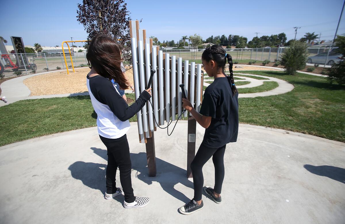 Two future students play an outdoor xylophone at the Westmont Elementary Visual and Performing Arts Academy on Thursday.