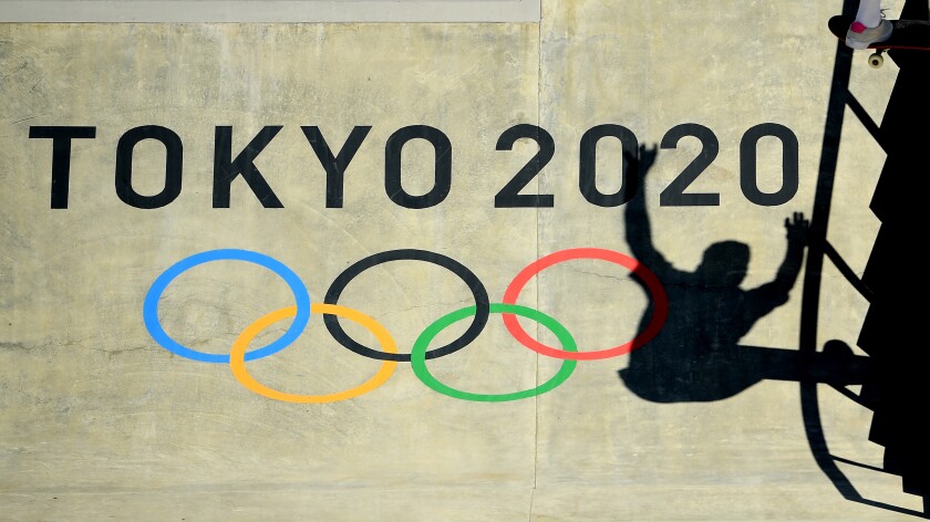 The shadow of a skateboarder over the Tokyo 2020 logo and Olympic rings