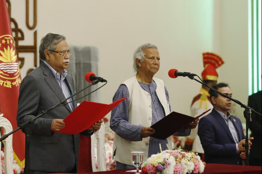 Bangladesh's figurehead President Mohammed Shahabuddin administers the oath of office to Nobel laureate Muhammad Yunus, right, as the head of Bangladesh's interim government, in Dhaka, Bangladesh, Thursday, Aug. 8, 2024. (AP Photo/Rajib Dhar)