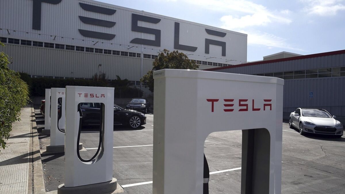 A row of new Tesla Superchargers are seen outside of the Tesla Factory on Aug. 16, 2013 in Fremont, Calif. Former contract workers have sued the automaker, alleging there was a pattern of racial harassment and hostility at the facility.