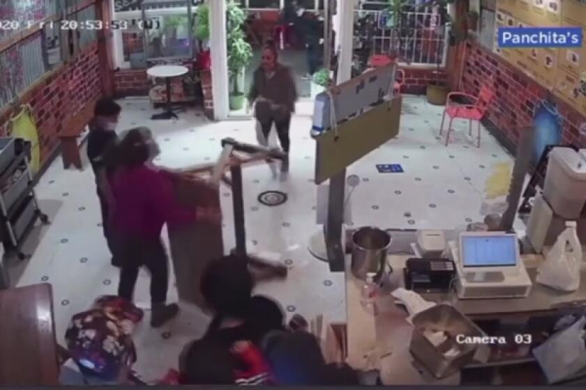 En esta imagen se observa a Doris Campos (camisa ocre) empujar una mesa en contra de una mujer agresiva.