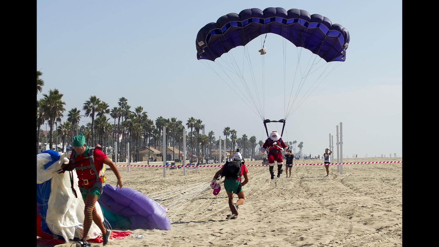 Santa Claus comes in for a landing in Huntington Beach near the Pacific City shopping center on Saturday.