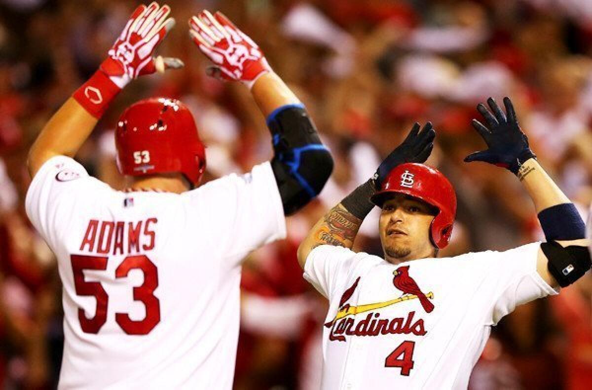 Cardinals catcher Yadier Molina (4) congratulates first baseman Matt Adams after he hit a two-run home run in the eighth inning of Game 5 in the National League division series against the Pittsburgh Pirates on Wednesday night at Busch Stadium in St Louis.