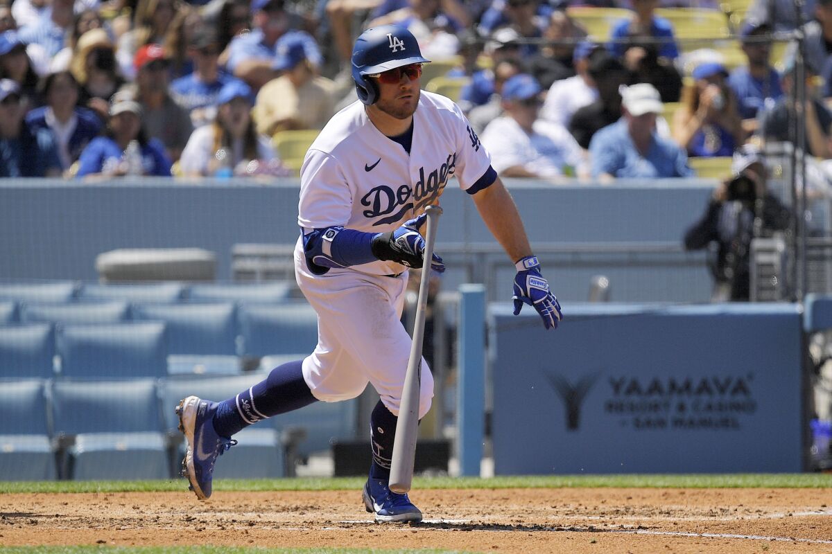 Max Muncy hits a two-run double against the Reds in the fourth inning Sunday.