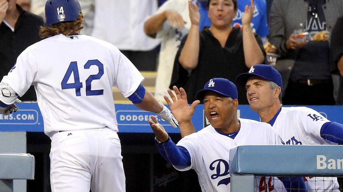 Dodgers Manager Dave Roberts congratulates Enrique Hernandez, who is wearing Jackie Robinson's No. 42, after he hit a home run against the Giants in the first inning Friday.
