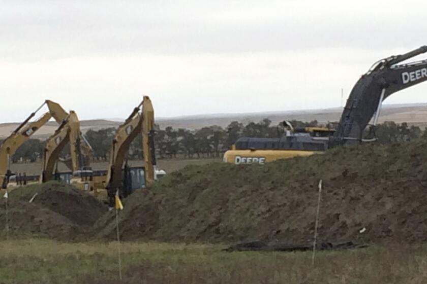 Excavators are in place as work resumed Tuesday on the four-state Dakota Access pipeline near St. Anthony, N.D.