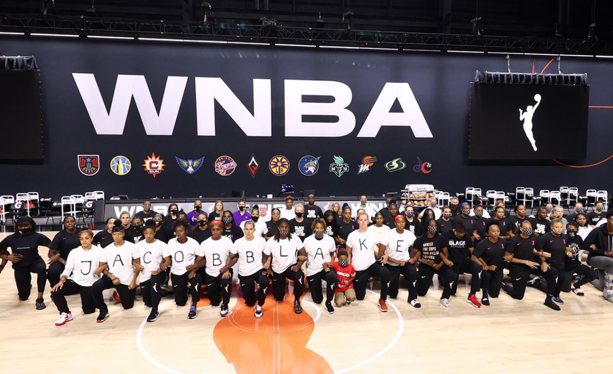 Members of four WNBA teams lock arms on court on Wednesday, the first day of the league's stoppage.