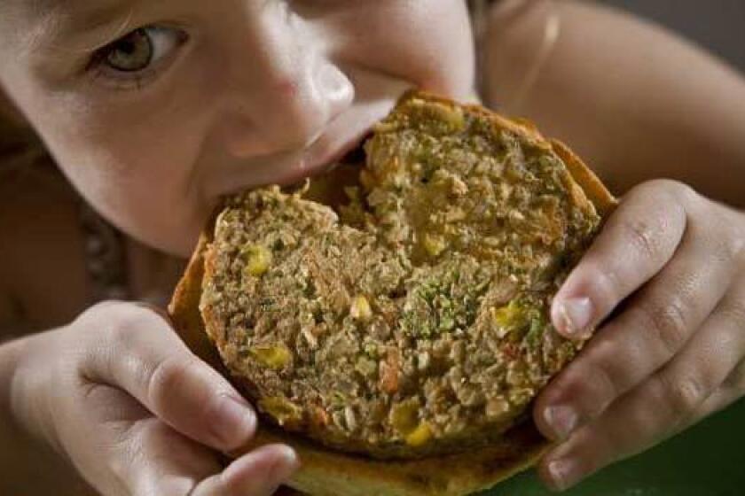 A child eats a garden burger from Whole Foods Market.