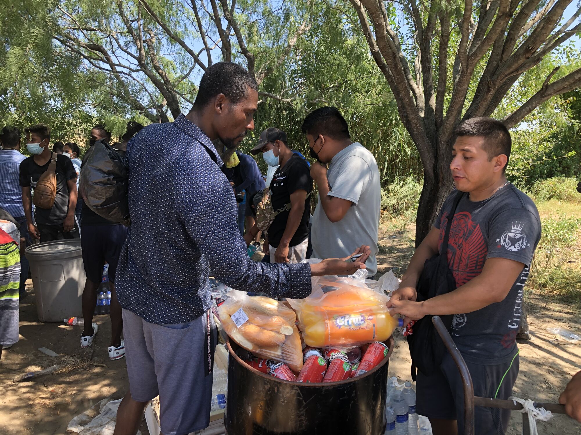 A Haitian migrant buys food near a crossing to Del Rio, Texas.